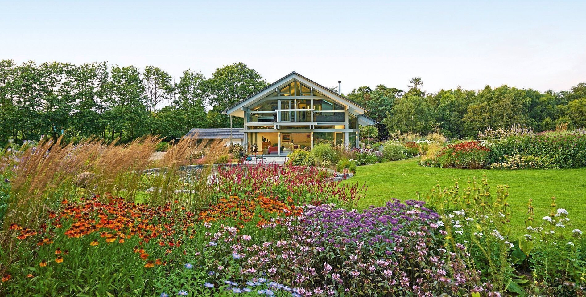 Blühende Blumen und ein modernes Haus in einer ländlichen Umgebung