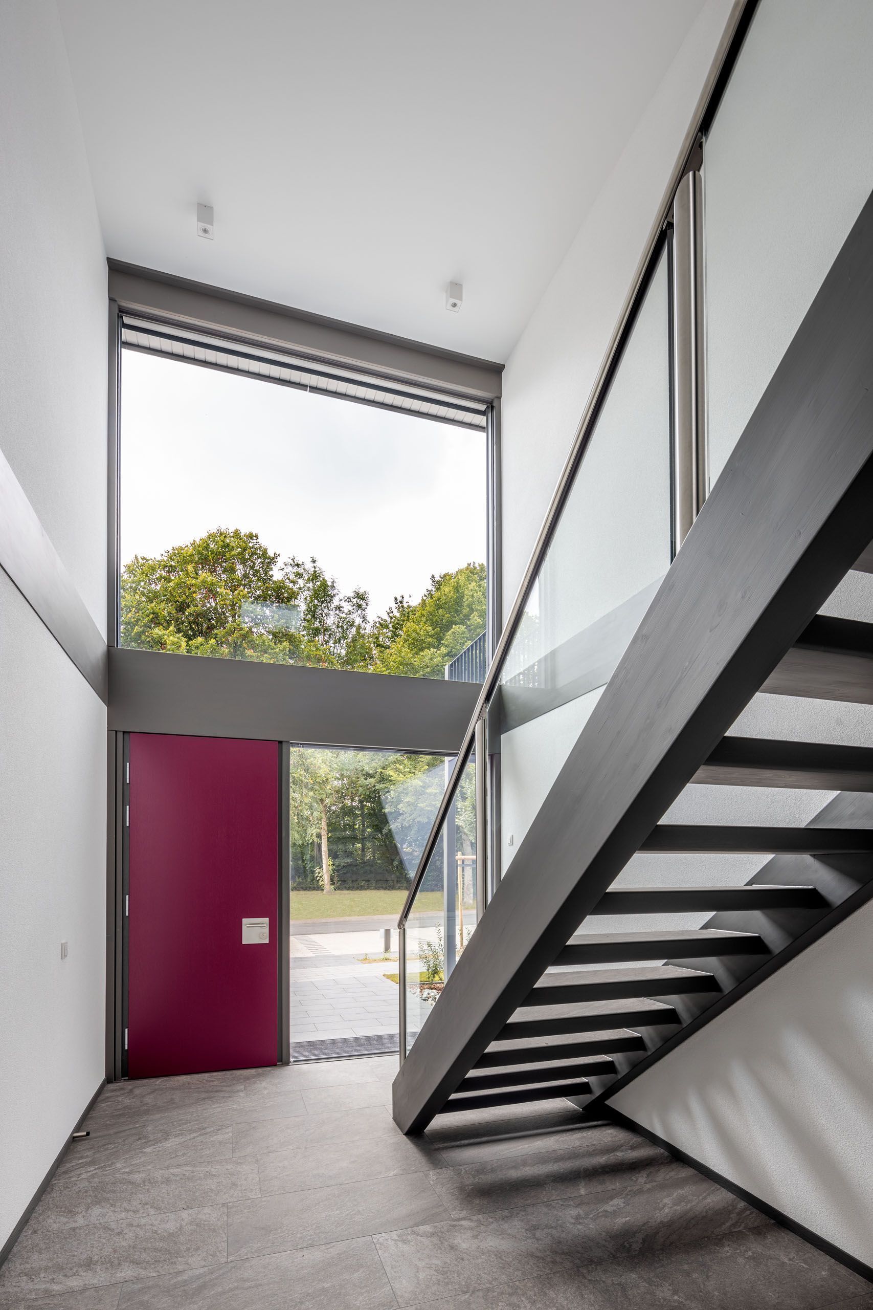 Moderne Fertighäuser in Hybridbauweise Innenansicht eines modernen Fertighauses mit Treppe und großer Fensterfront