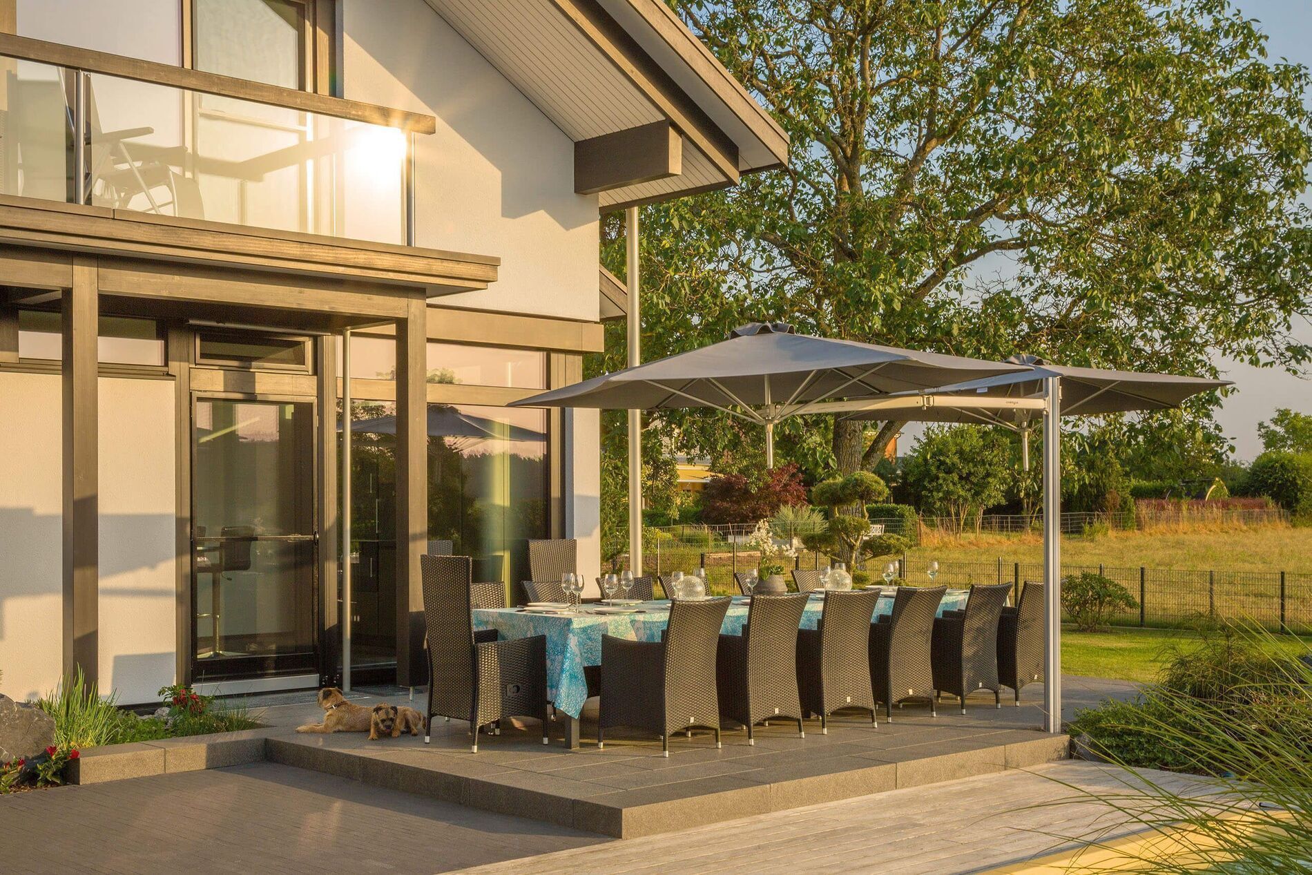 Schöne Terrasse mit modernen Möbeln und Sonnenschutz, umgeben von Natur