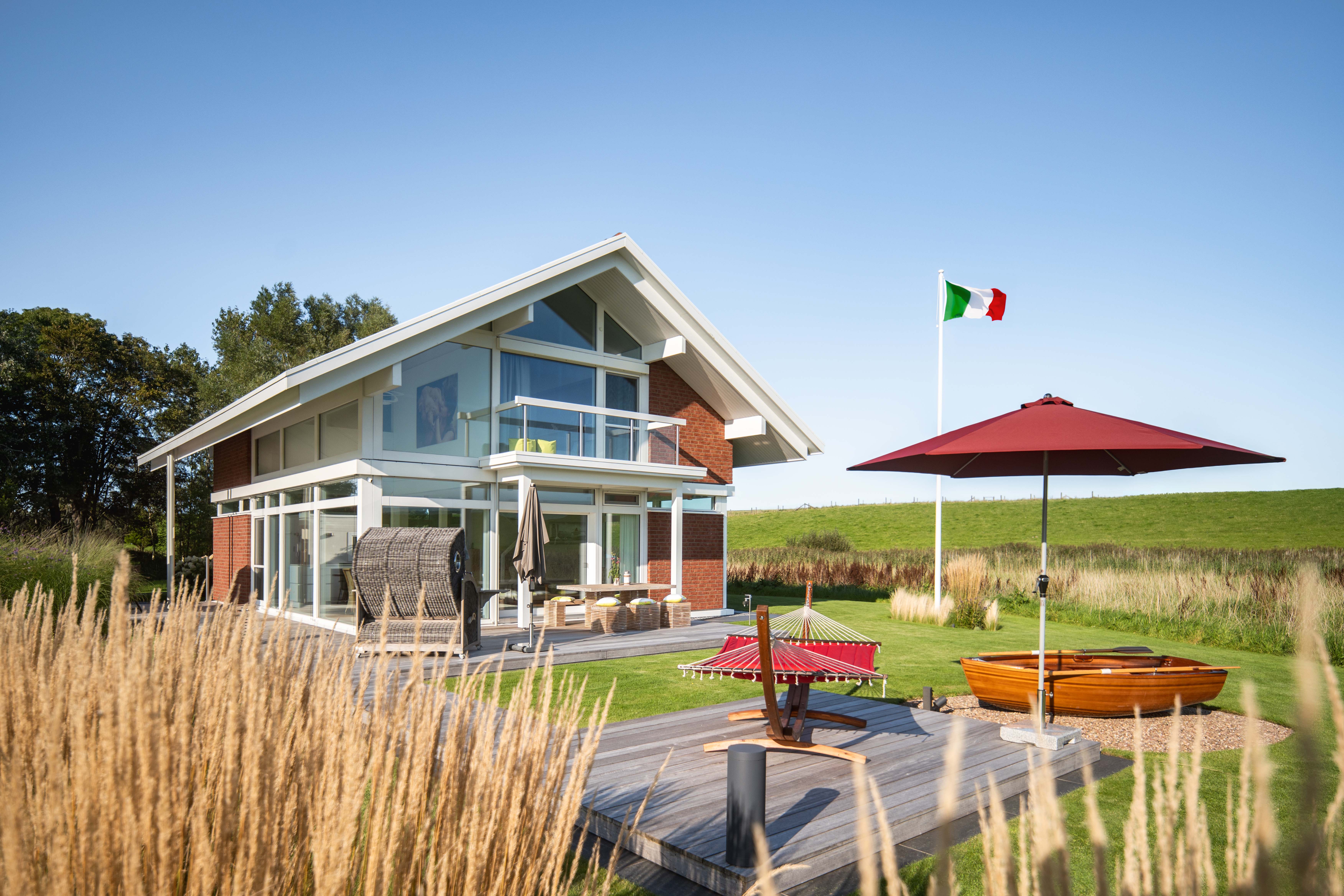 Stilvolles Architektenhaus mit Garten und Terrasse Gemütliches Familienhaus mit Flaggen, Sonnenschirm und Booten