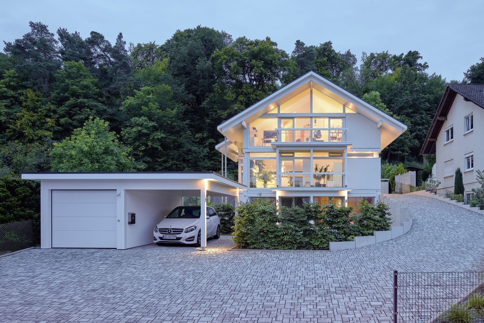 Elegantes Haus mit Carport, umgeben von Natur und beruhigenden Farben