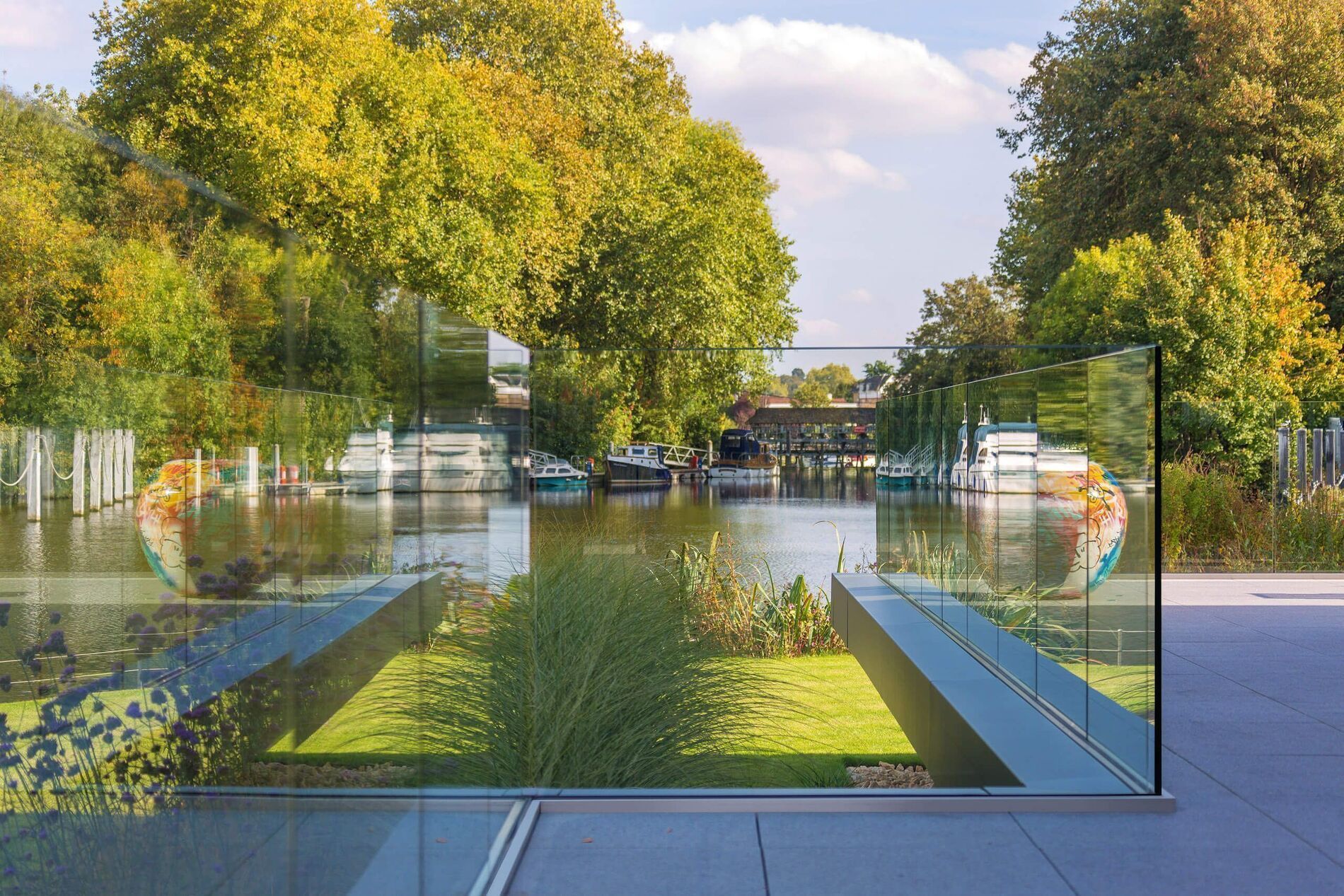 Moderne Architektur mit Glas und Garten, umgeben von Natur