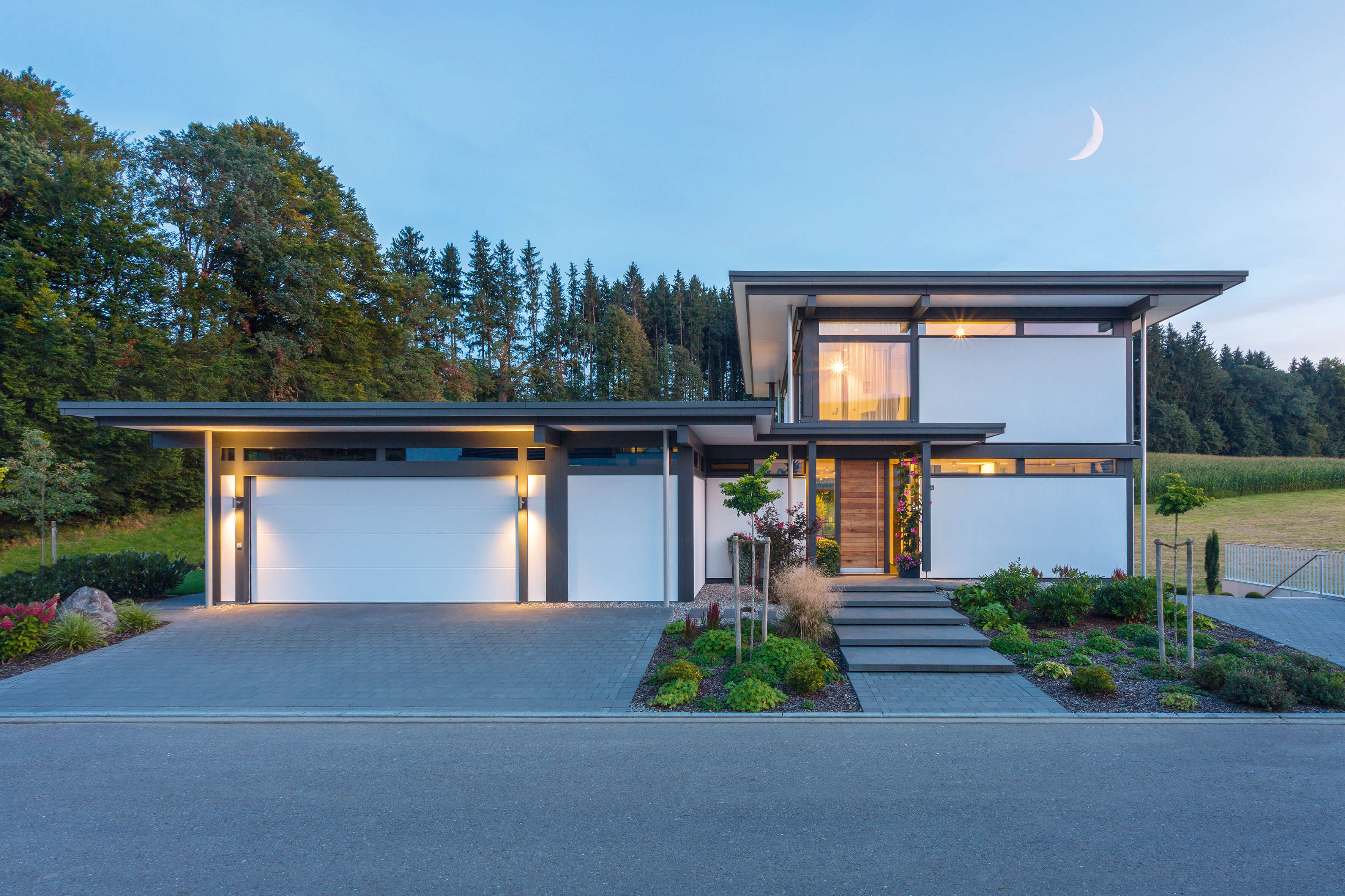 Stilvolles modernes Fachwerkhaus in der Dämmerung Moderne Architektur eines Fachwerkhauses mit schöner Landschaft
