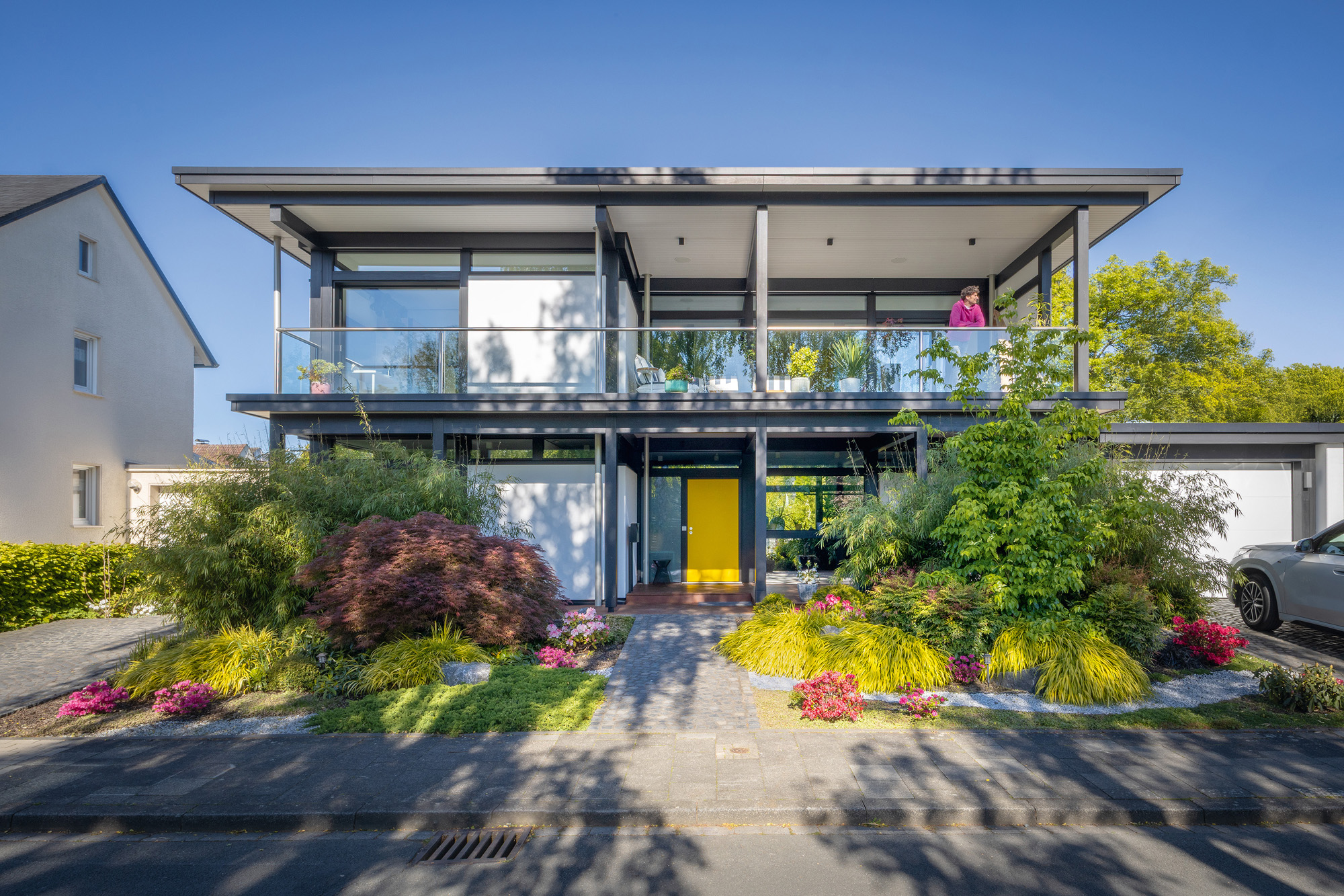 Modernes Designhaus mit Flachdach und Gartenanlagen Stilvolles modernes Haus mit Flachdach und bunten Blumen im Garten