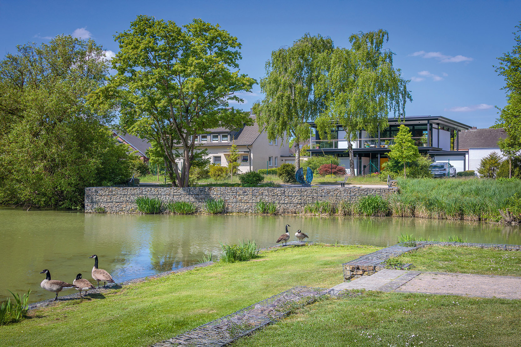 Modernes Designhaus mit Flachdach am Wasser Zeitgenössisches Designhaus in grüner Umgebung mit Wassersicht