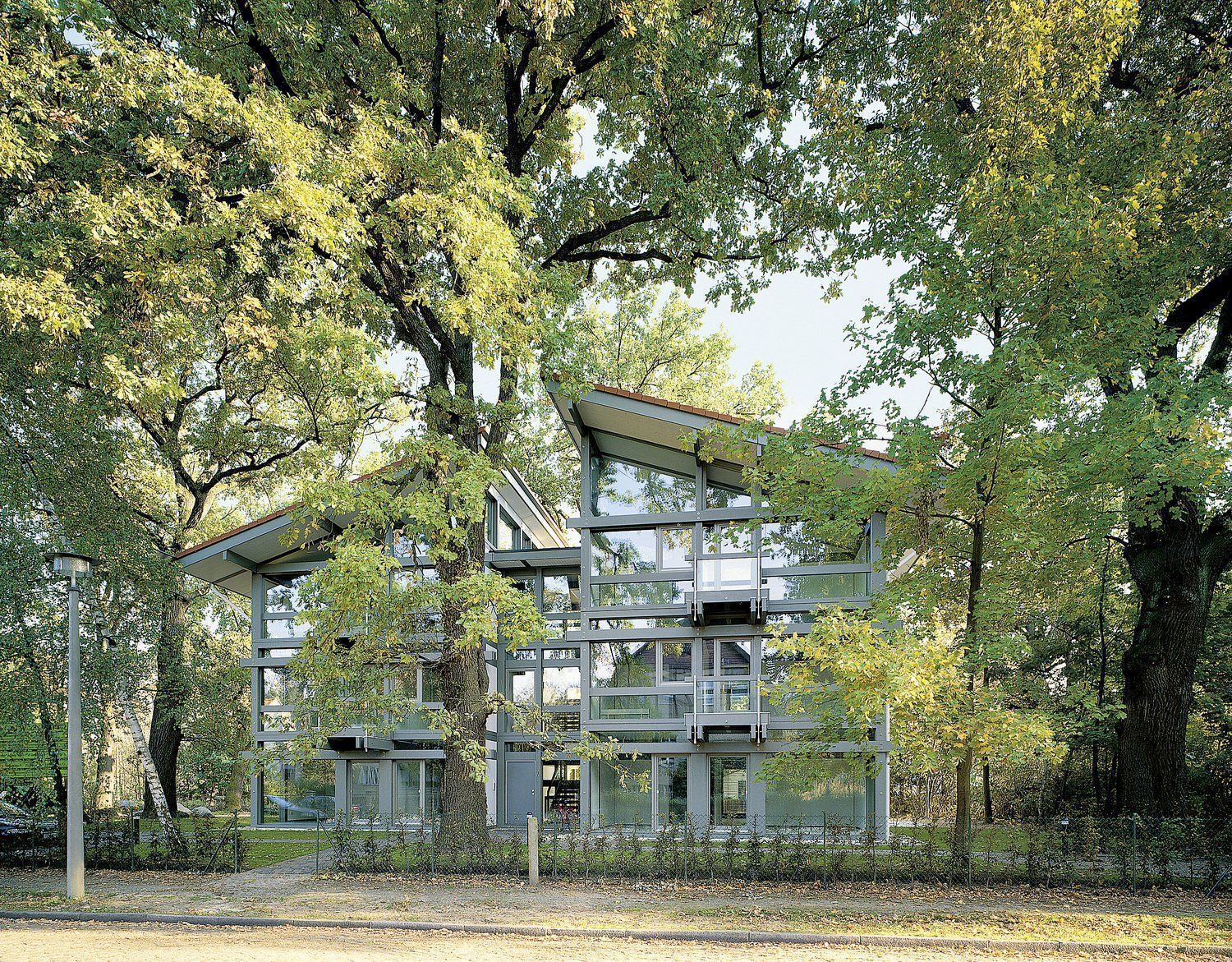 Modernes Mehrfamilienhaus von HUF HAUS Offene und großzügige Architektur inmitten von Bäumen