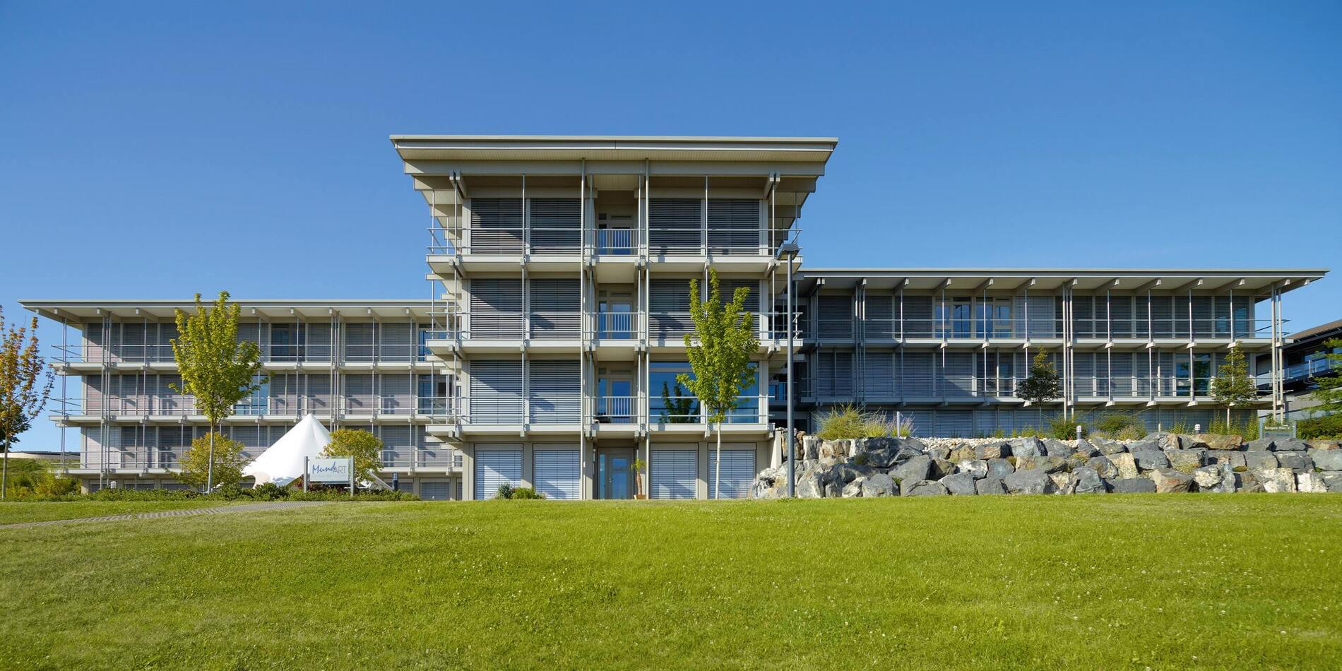 Bürogebäude HUF bei klarem Himmel Moderne Architektur des Bürogebäudes HUF mit grünem Rasen