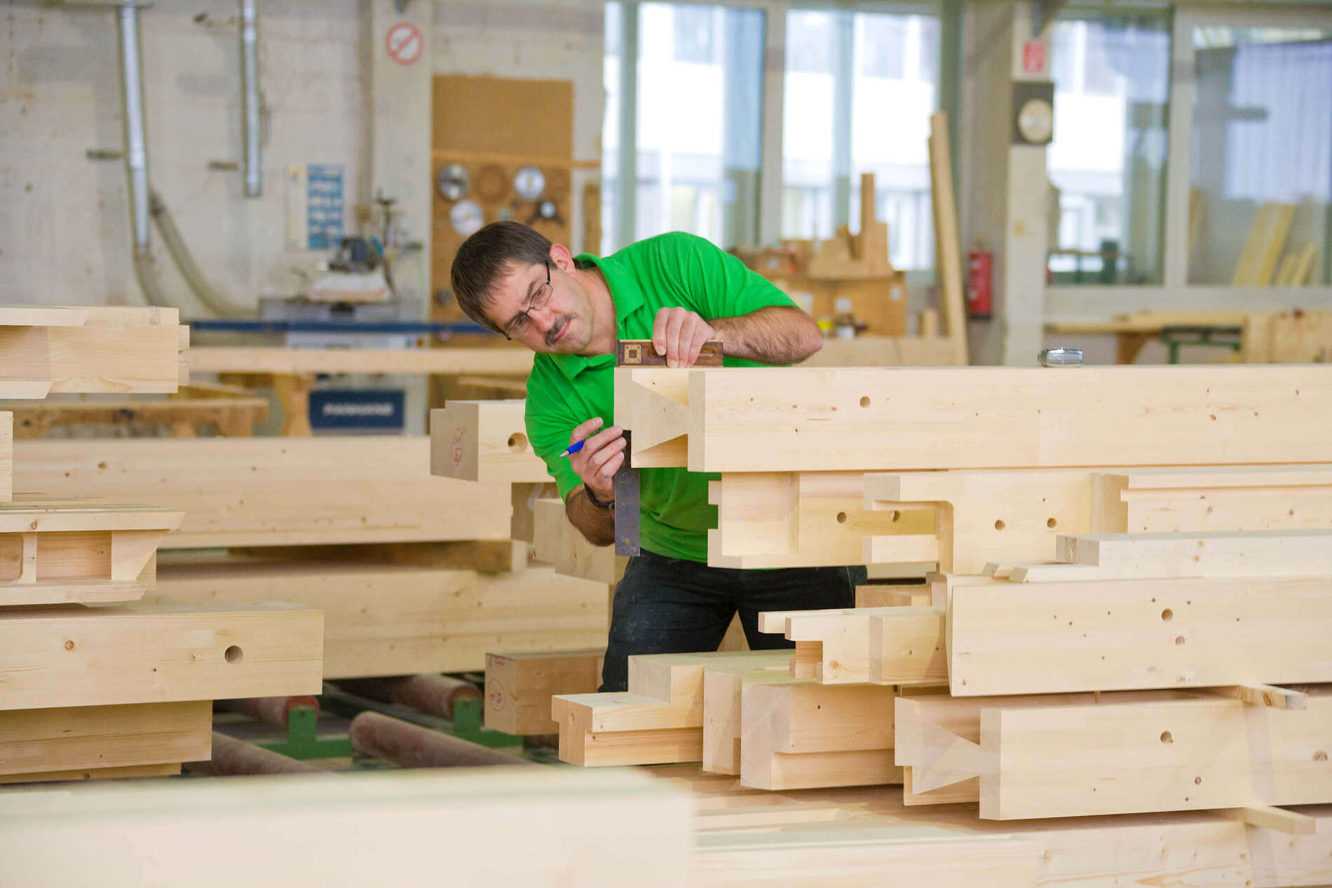 Handwerker prüft Holzstücke in einer Holzwerkstatt