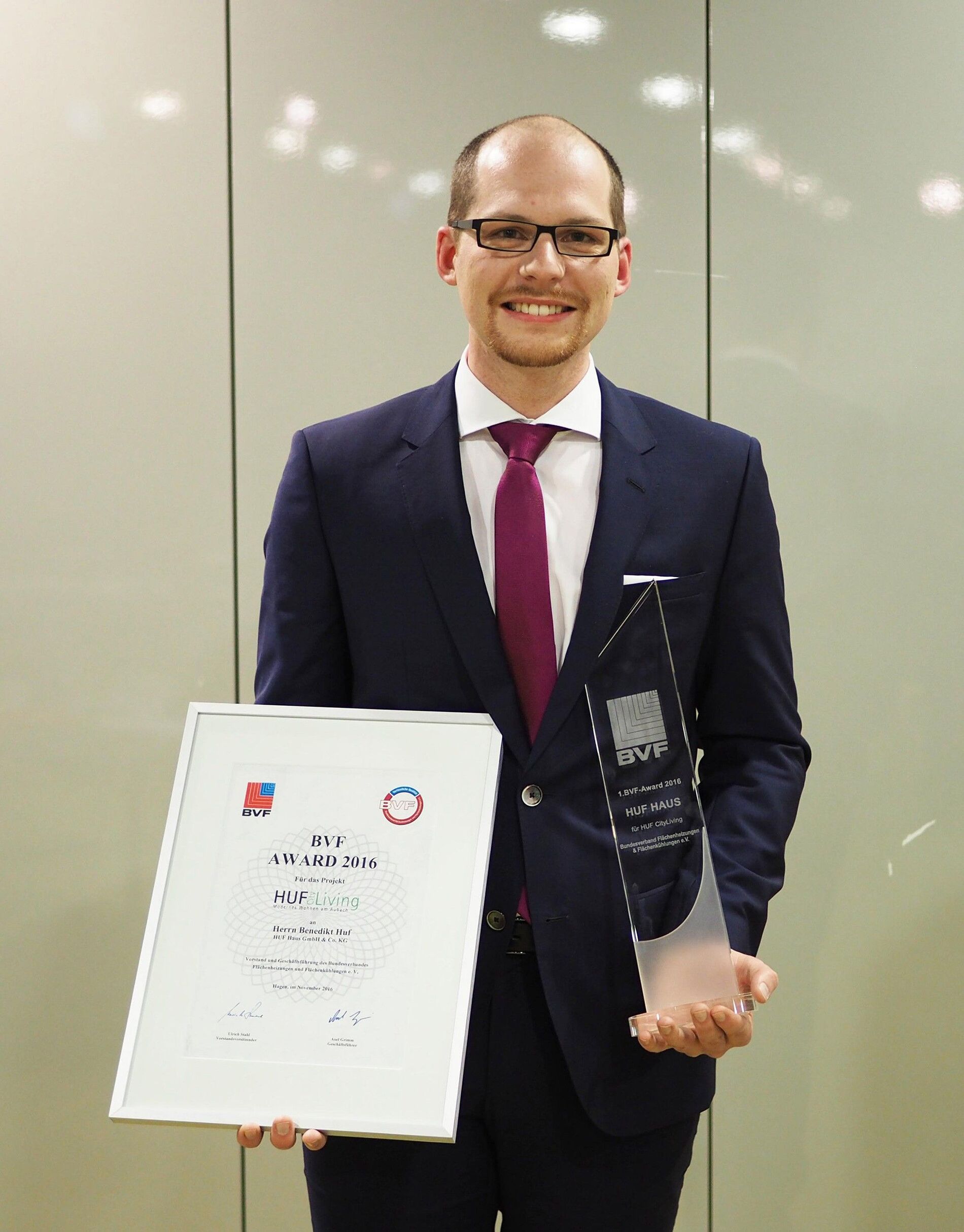 Person holding an award and certificate Individual smiling with a certificate and a trophy in hands.