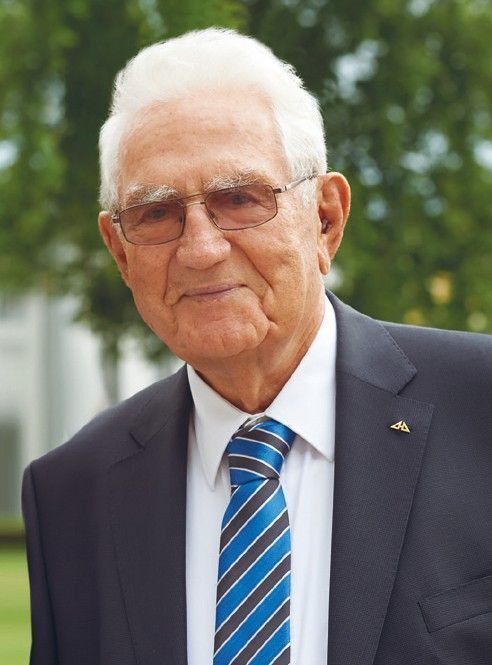 Älterer Mann mit Brille und Anzug im Freien Ein gentleman in einem Anzug mit blauer Krawatte und Sonnenbrille