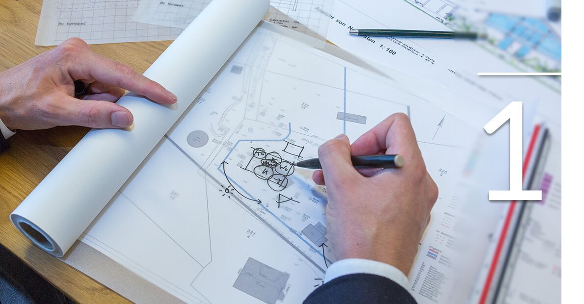 Planung eines Bauprojekts mit technischen Zeichnungen Eine Hand skizziert auf einem Bauplan mit Rollpapier