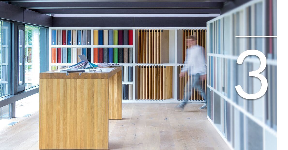 Moderne Innenarchitektur mit Farbmustern Ein Innenraum mit Holztisch und farbigen Musterregalen.
