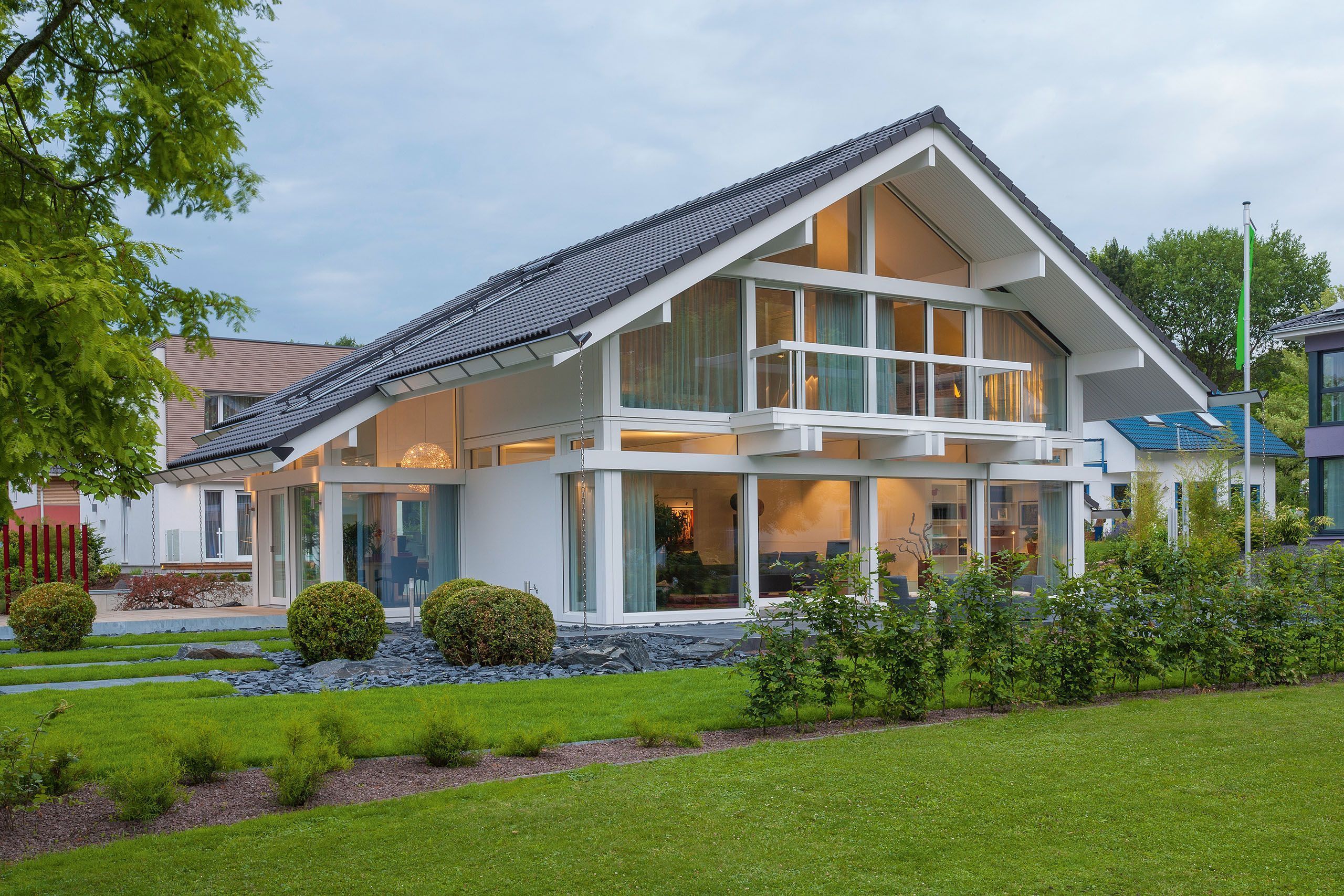 Stylisches modernes Haus mit großen Fenstern und gepflegtem Grün