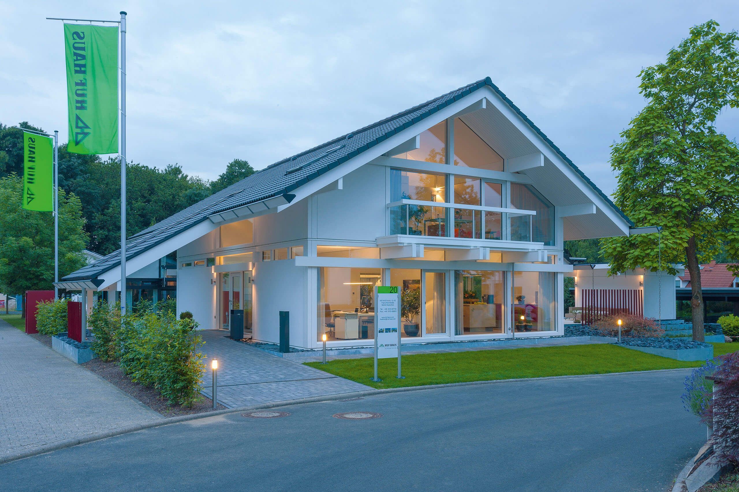 HUF Musterhaus Frankfurt weiss 6 Helles, modernes Haus mit großen Fenstern und Garten.