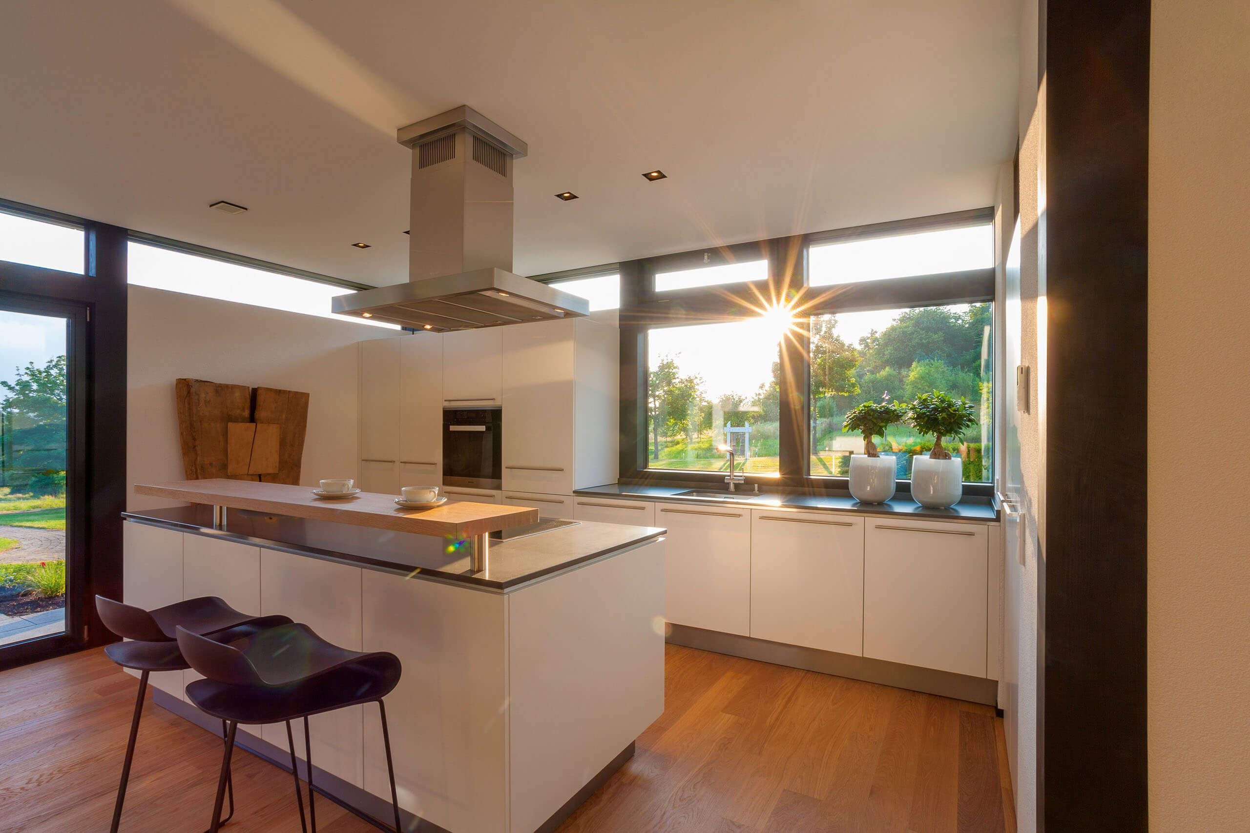 Helle Küche mit Holzdetails und großem Fenster im Sonnenlicht