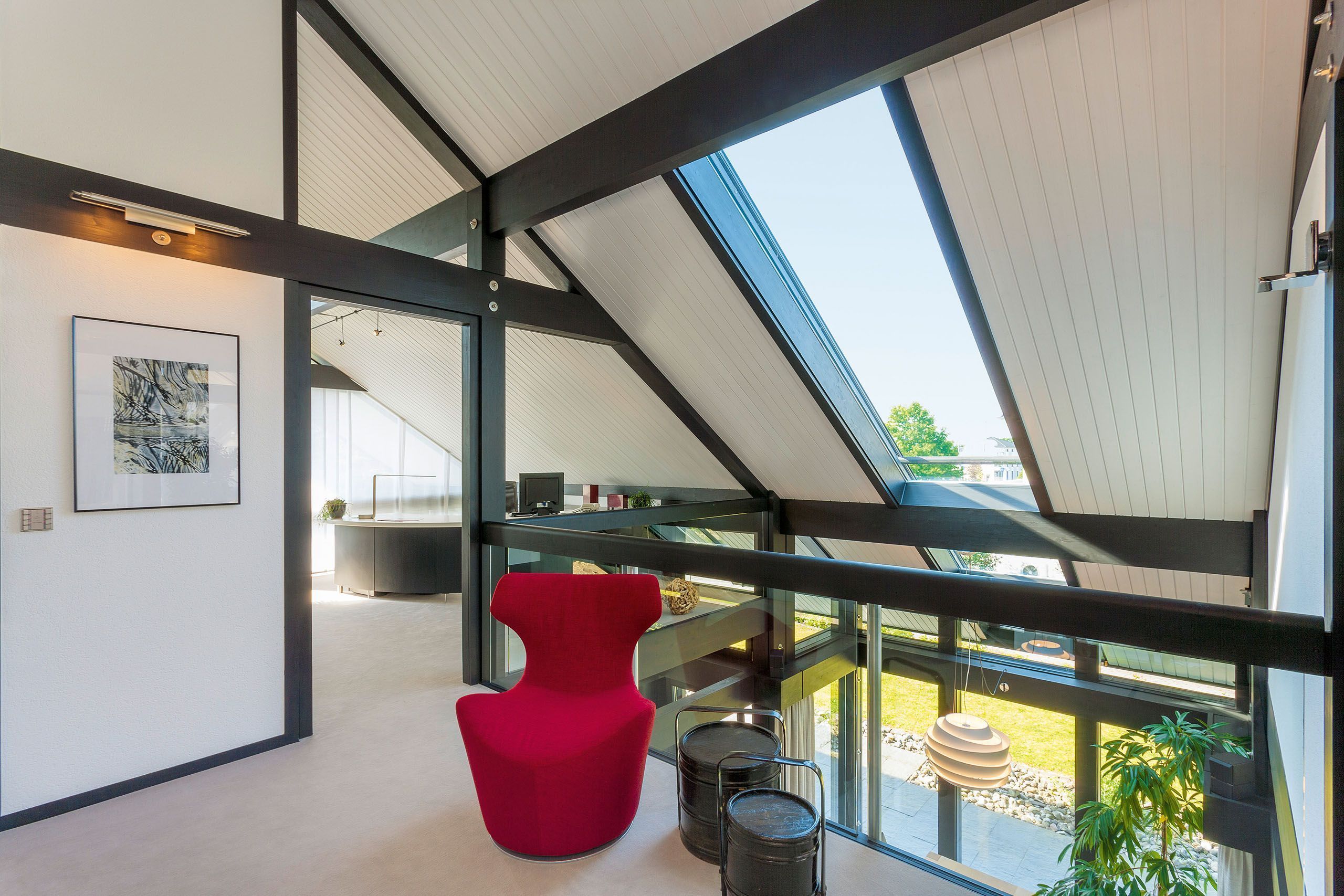Stylish interior featuring a red chair and large windows