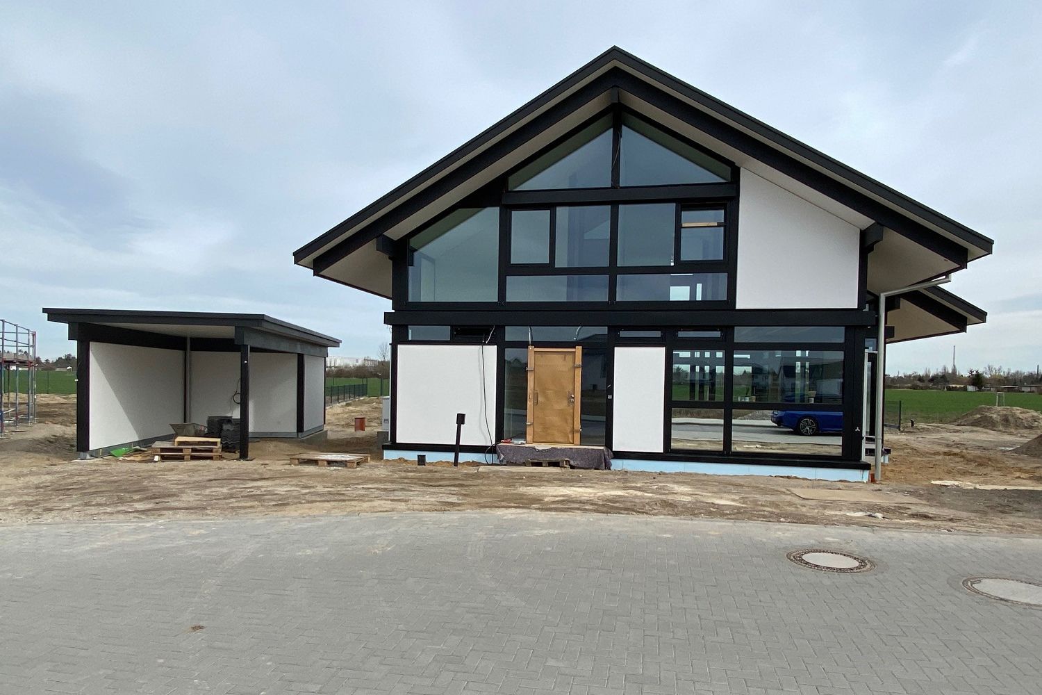 Ansicht eines neugebauten Hauses mit großen Fenstern und Holzrahmen