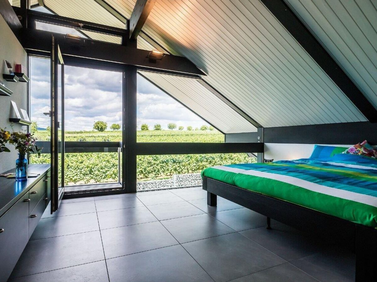 Helle Schlafzimmeransicht mit Blick auf eine Weinlandschaft