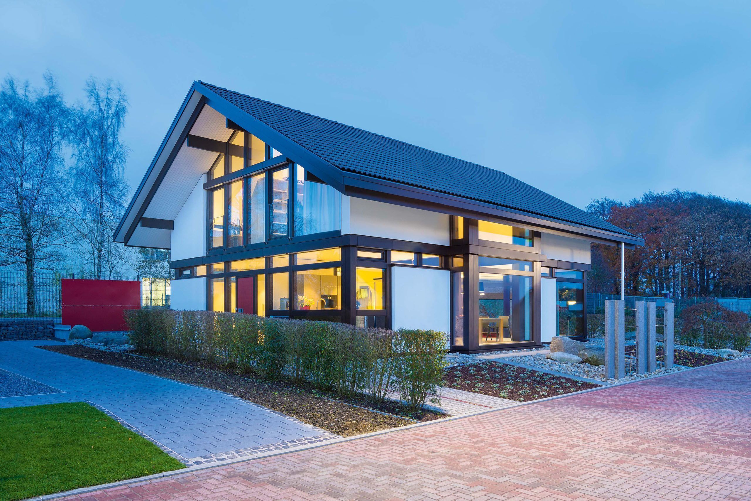 HUF Haus modum 810 Musterhaus Wuppertal 13 Einfamilienhaus mit großen Fenstern und stilvollem Design in der Dämmerung