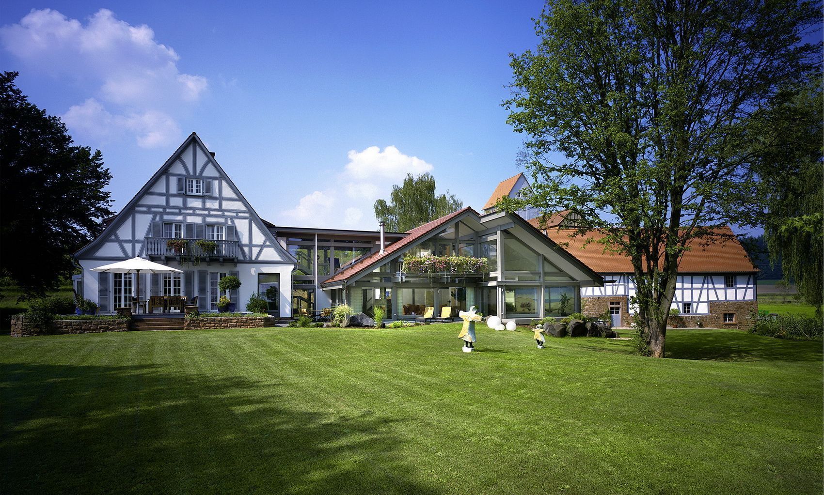 Moderne Landhausarchitektur mit Garten und Kindern Helles Landhaus mit Gartenlandschaft und spielenden Kindern