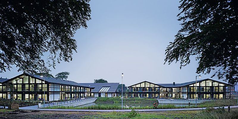 Moderne Architektur in einer ruhigen Umgebung Zwei moderne Gebäude in einer grünen Landschaft bei Dämmerung