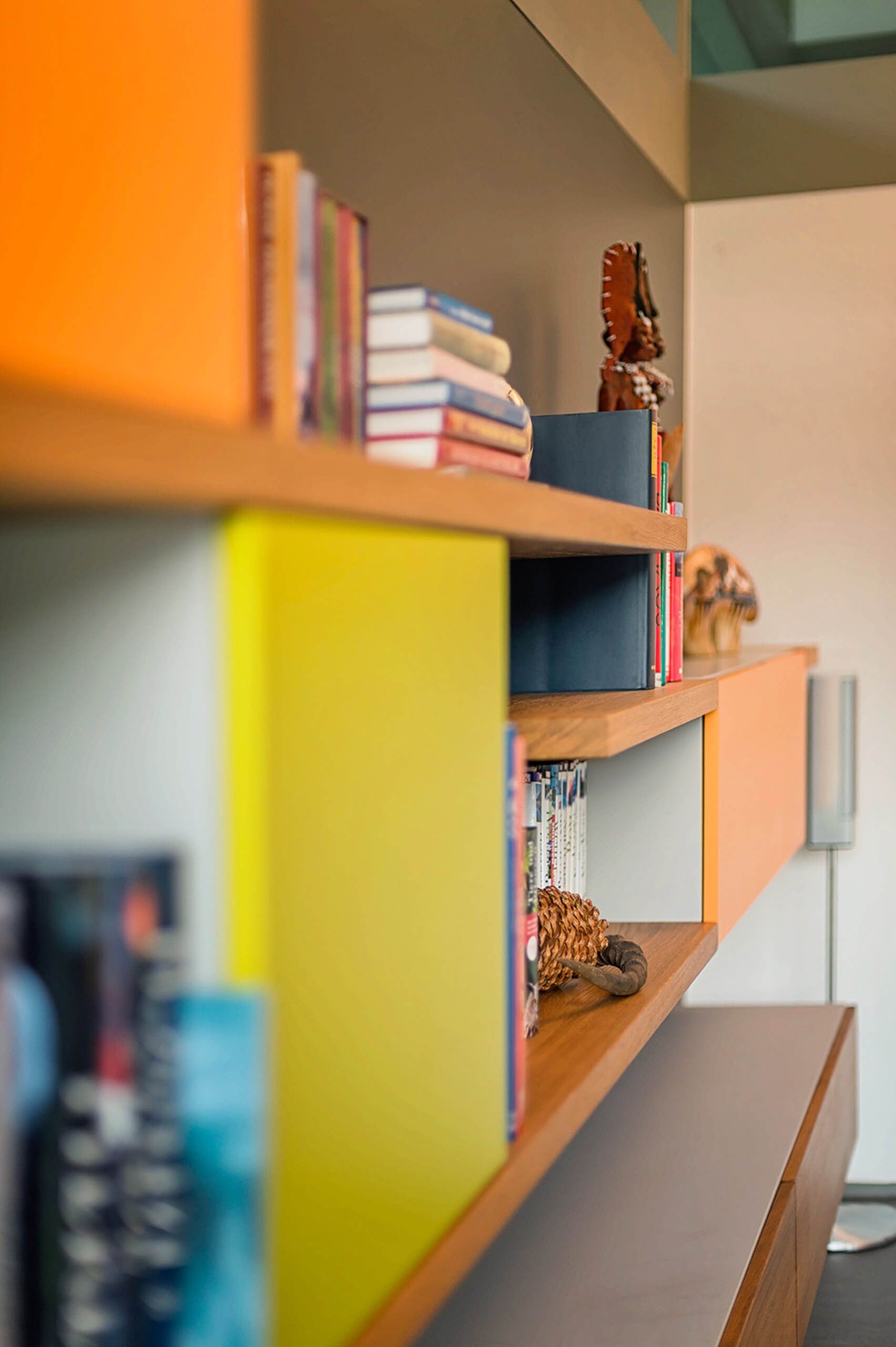 Helles Regalsystem mit Bücher und dekorativen Objekten.