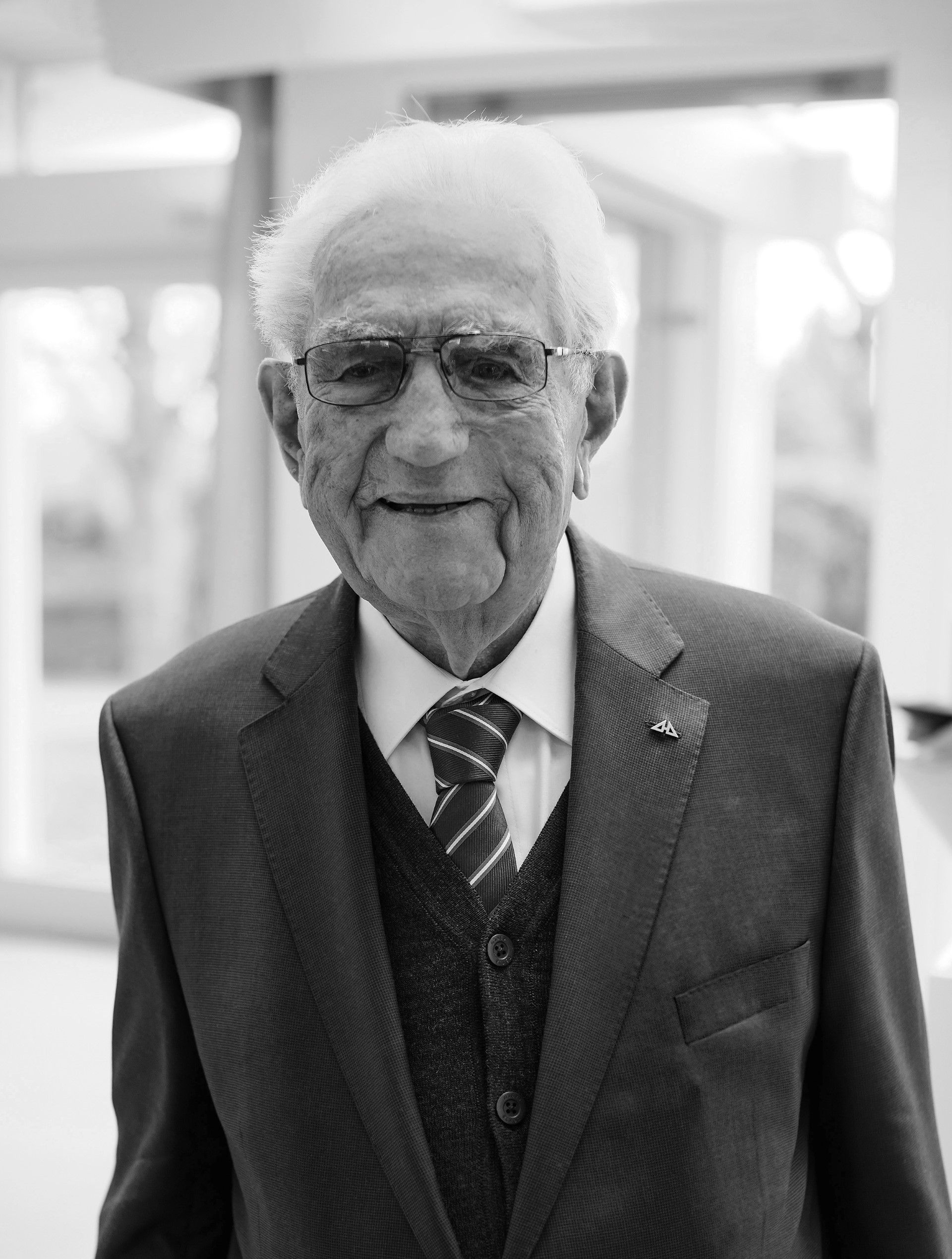 Schwarz-weiß Bild eines älteren Mannes mit Brille und Anzug