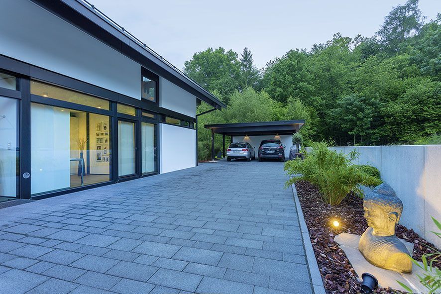 Moderne Architektur mit Doppelgarage und Garten Ein modernes Haus mit einer Doppelgarage und einer Gartenlandschaft.
