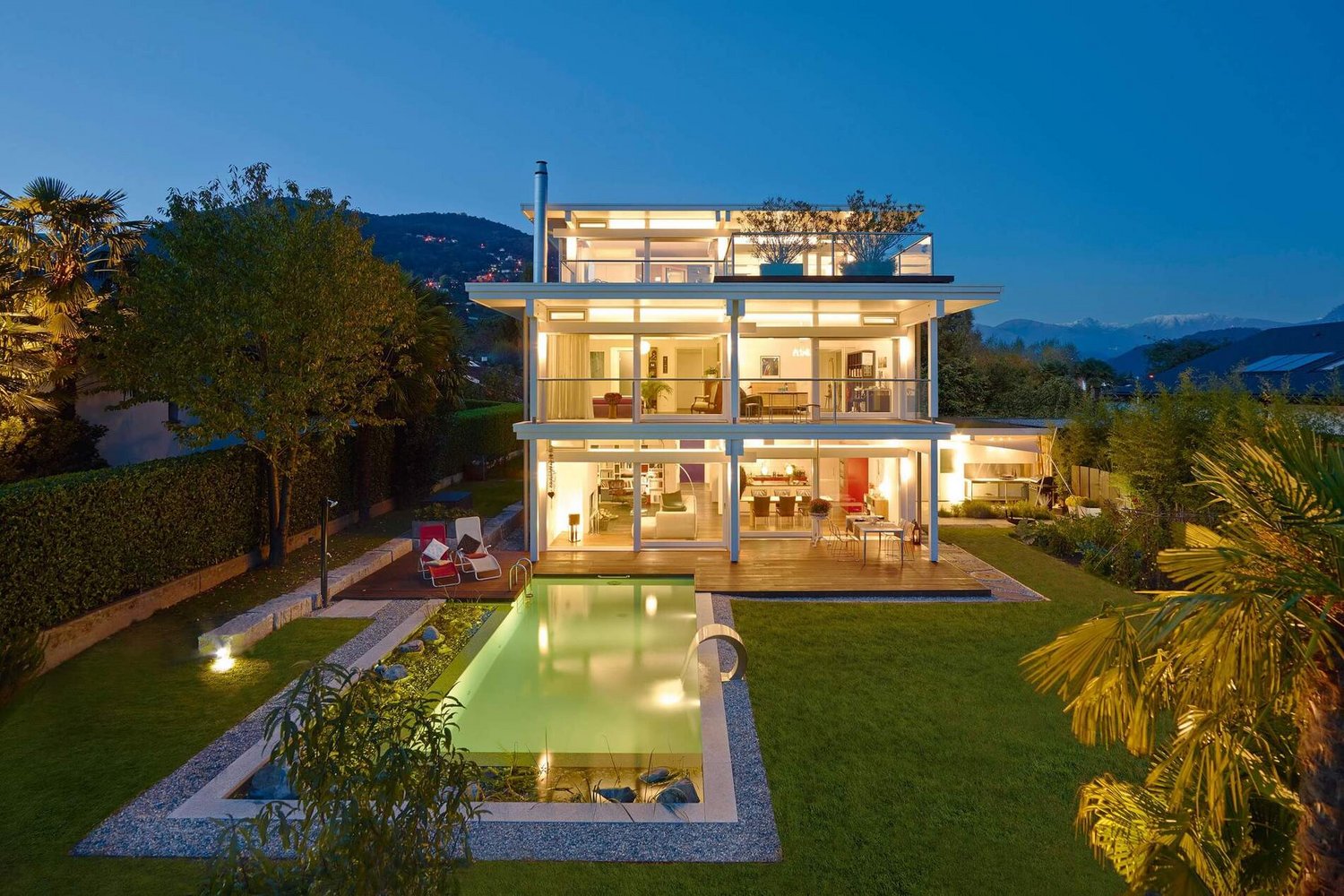 Modernes HUF Flachdachhaus mit eleganter Architektur Stilvolles Flachdachhaus mit Pool und modernem Design bei Nacht