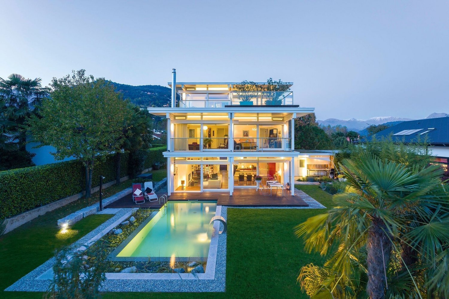 Modernes HUF Flachdachhaus mit eleganter Architektur HUF Flachdachhaus mit Pool und klaren Linien in der Abenddämmerung
