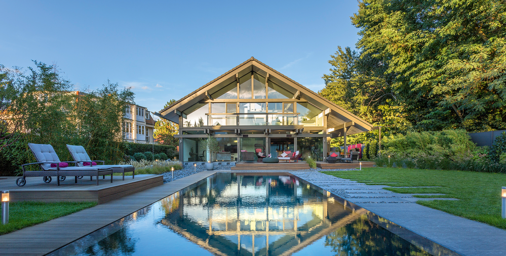 Moderne Villa mit Pool und Gartenlandschaft Helle Architektur einer Villa mit Pool und angrenzendem Garten