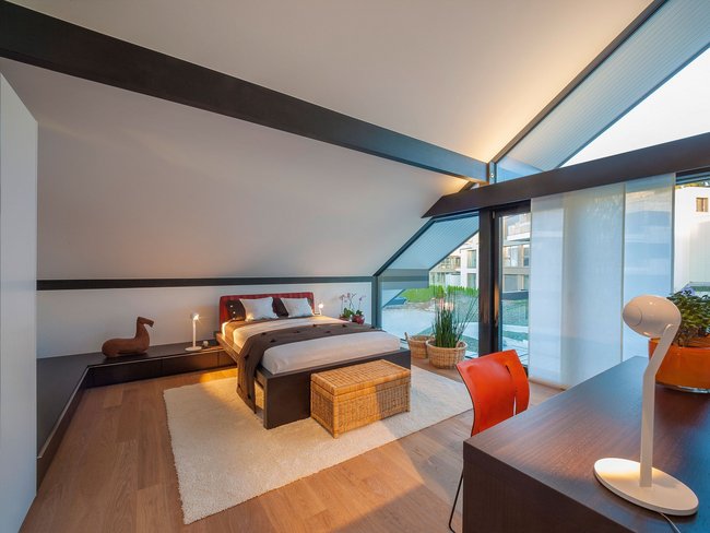 Ein stilvolles Schlafzimmer mit Holzfußboden und großen Fenstern