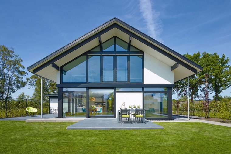 Haus mit Glasfassade und einem grünen Garten in sonniger Umgebung