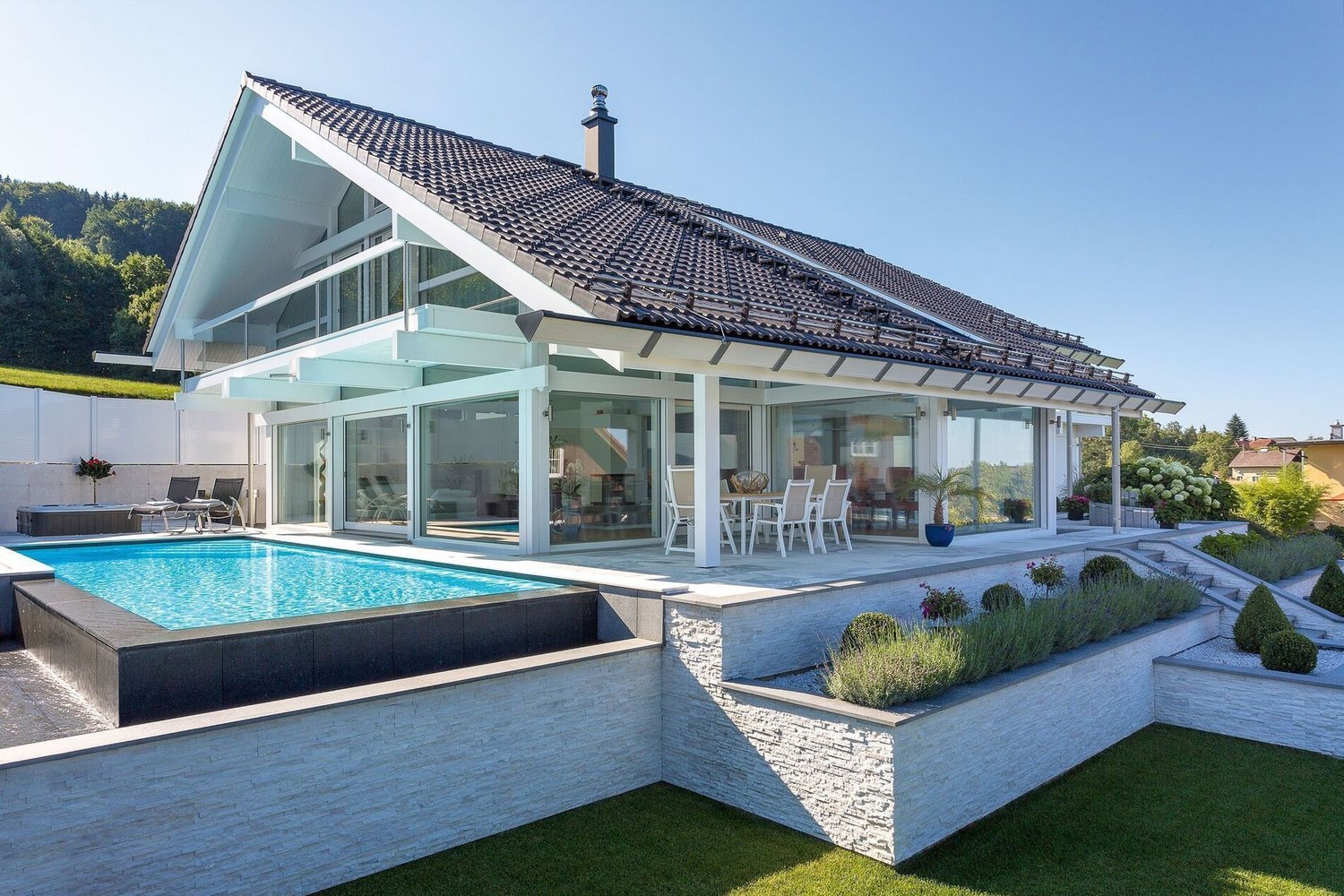 Moderne HUF Architektur mit Pool und Landschaftsblick Transparente Architektur mit Blick auf Hügel und See vom Terrassengarten
