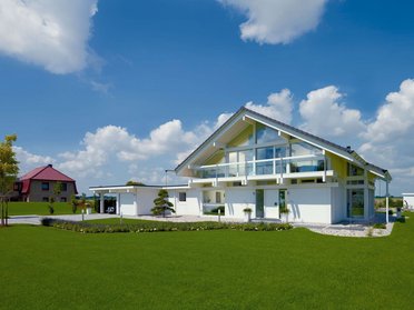 Modernes Fachwerkhaus mit großen Fenstern und grünem Rasen