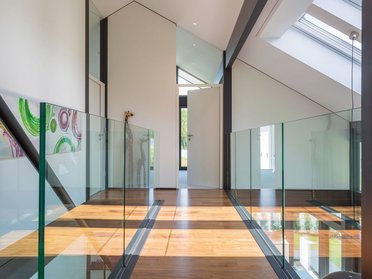Gemütliches Architektenhaus mit stilvollem Eingang Innenansicht eines modernen Familienhauses mit Glasgeländer und viel Licht