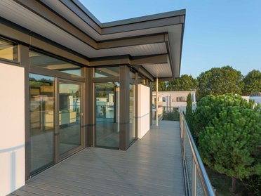 Moderne HUF Aufstockung eines Bestandshauses Balkonansicht einer HUF Aufstockung mit modernen Fenstern und Holzterrasse