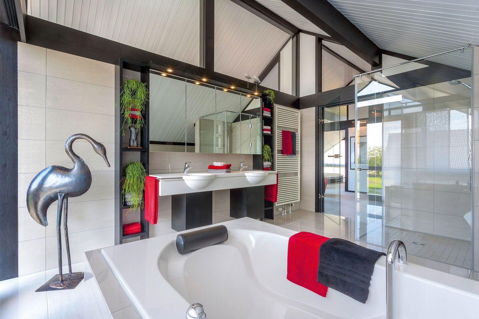Helles Badezimmer mit Wanne, Spiegeln und stilvollen Dekorationen