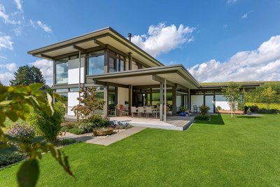 Helles modernes Fachwerkhaus mit großem Garten und blauen Himmel