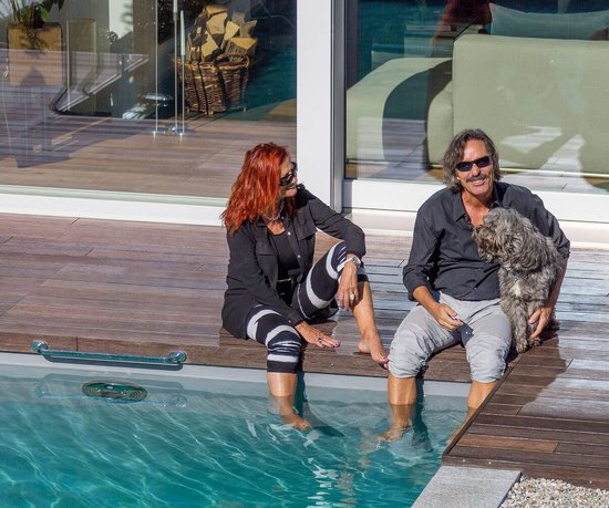 Moderne Architektur mit Pool und entspannter Atmosphäre Paar mit Hund am Pool, umgeben von moderner Architektur und Garten