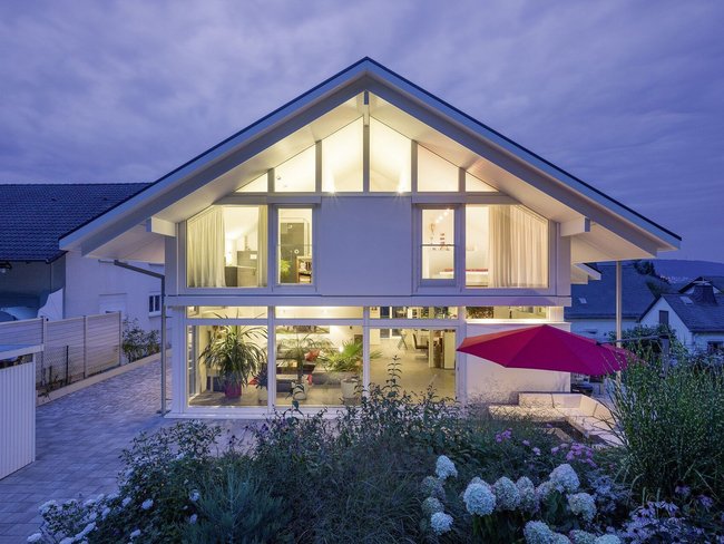 Ein elegantes Haus mit großen Fenstern und umliegendem Gartenbeleuchtung