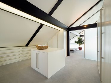 Helles und geräumiges Schlafzimmer mit weißen Wänden und Möbeln