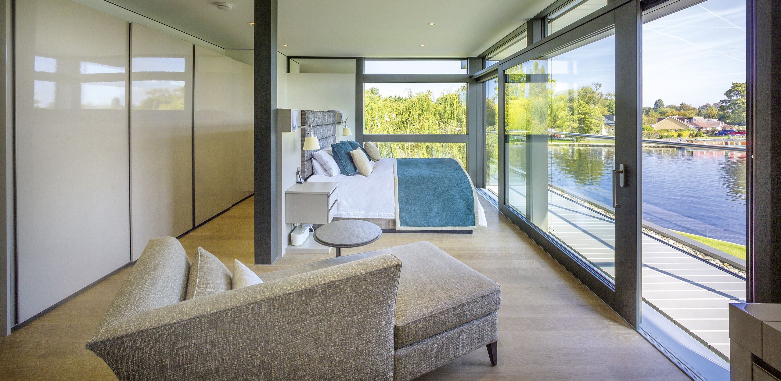 Moderne Schlafzimmeransicht mit Blick auf den Wasserweg Elegantes Schlafzimmer mit großen Fenstern und Wasseraussicht