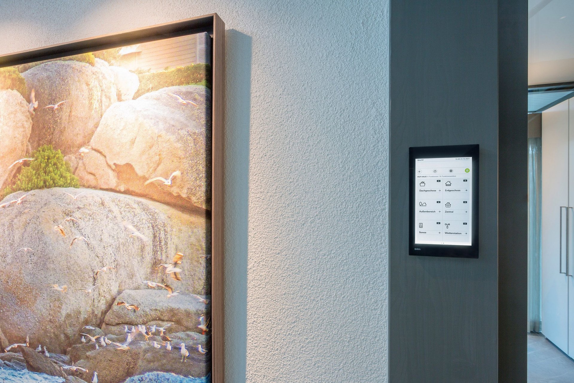 Modern interior with art and digital control panel A sleek wall featuring artwork and a digital touchscreen interface
