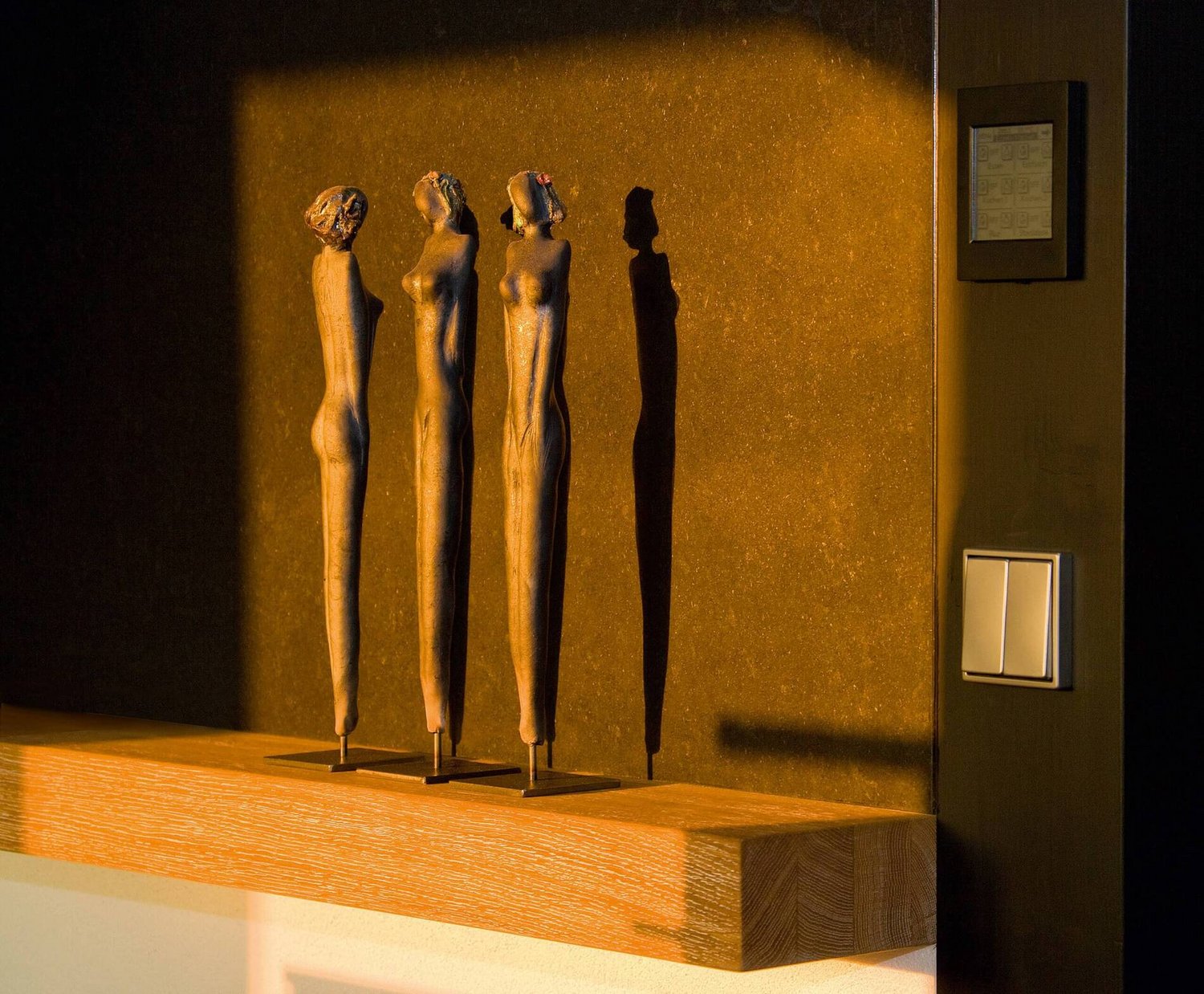 Architektenhaus mit Skulpturen im Licht Drei stilisierte Skulpturen werfen Schatten auf eine Wand