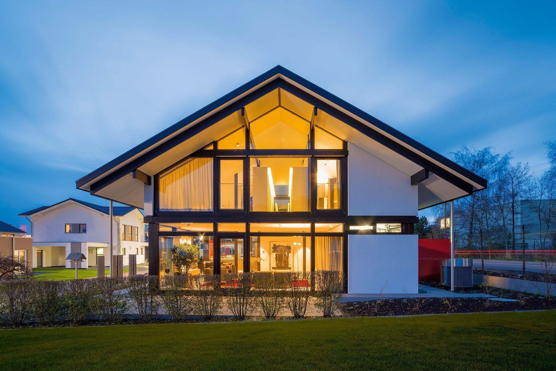 Architektur eines modernen Hauses mit warmem Licht und Garten