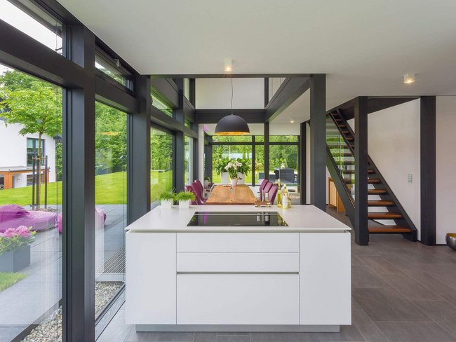Modernes Architektenhaus mit stilvollem Innenraum Gemütliche Küche mit Blick auf den Garten und stilvollen Möbeln