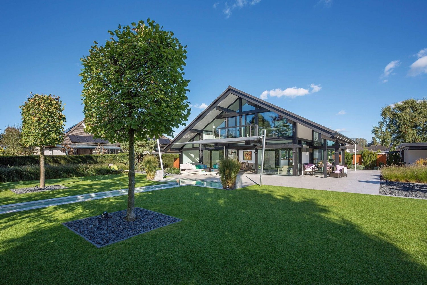Modernes Fachwerkhaus aus Holz und Glas im Garten Transparentes Haus mit Bachlauf und grünem Panorama