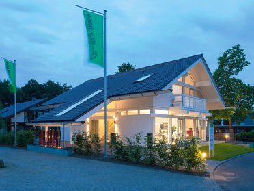 HUF Musterhaus Frankfurt weiss 15 Ein hell erleuchtetes, modernes Haus bei Dämmerung