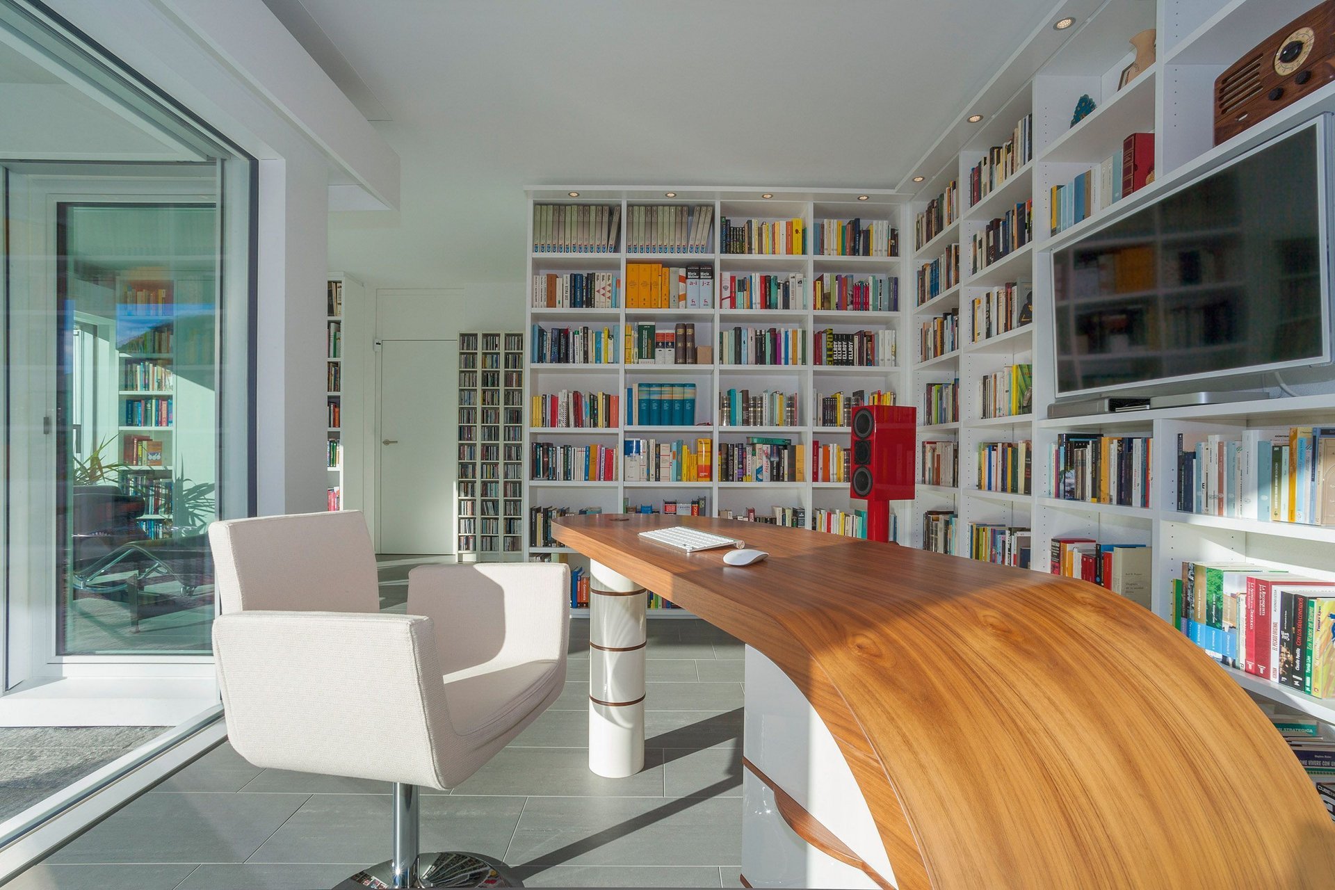 Ein stilvolles Arbeitszimmer mit einem Holzschreibtisch und bunten Bücherregalen